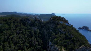 Kayalık kayalıkların ve yemyeşil bitki örtüsünün, İbiza kıyısındaki Akdeniz 'in engin genişliğiyle buluşması nefes kesici bir manzara. hız rampası hiper hareket zaman aşımı 