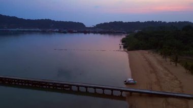 Tayland 'ın Koh Chang şehrinde günbatımında sakin suyu yansıtan geleneksel yüzen köyün hava manzarası. doly sağ drone 