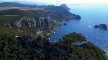 İbizas görkemli kayalıklarının ve turkuaz suların manzaralı manzarası Akdeniz güzelliğinin özünü yakalıyor. uçuş üstü insansız hava aracı 