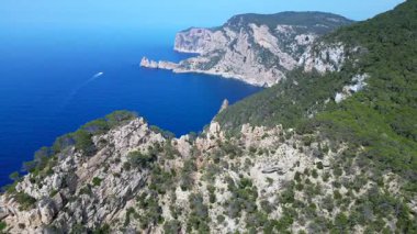 İbizas görkemli kayalıklarının ve turkuaz suların manzaralı manzarası Akdeniz güzelliğinin özünü yakalıyor. uçuş üstü insansız hava aracı 