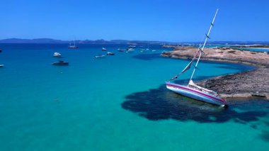 Yelkenli, güneşli bir yaz gününde İspanya 'nın Formentera Adası kıyılarında mahsur kaldı. Sol İHA 'ya dön 