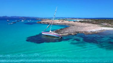 Yelkenli, güneşli bir yaz gününde İspanya 'nın Formentera Adası kıyılarında mahsur kaldı. Ters İHA uçuşu 