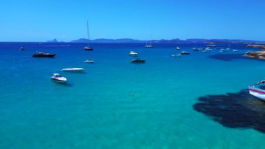 Yelkenli, güneşli bir yaz gününde İspanya 'nın Formentera Adası kıyılarında mahsur kaldı. Sağ drona döndür 