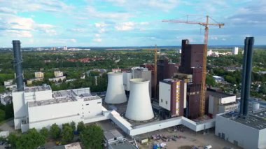 Dönüşüm, yenilenme ve yenilenme sürecinde olan elektrik santrali, soğutma kuleleri, bacalar ve inşaat vinciyle donatıldı. panorama yörünge dronu 