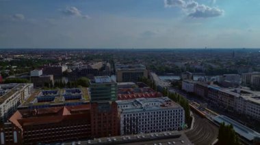 Güneşli bir günde Amazon merkez kulesi, demiryolu hatları ve modern mimarisi olan Berlin şehir manzarası. Sağ drona döndür 