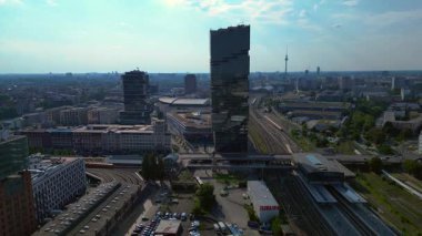 Güneşli bir günde Amazon merkez kulesi, demiryolu hatları ve modern mimarisi olan Berlin şehir manzarası. geniş yörünge görünümü dronu 