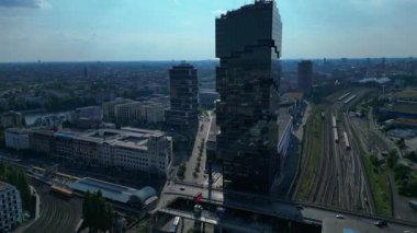 Güneşli bir günde Amazon merkez kulesi, demiryolu hatları ve modern mimarisi olan Berlin şehir manzarası. İHA yükseliyor 