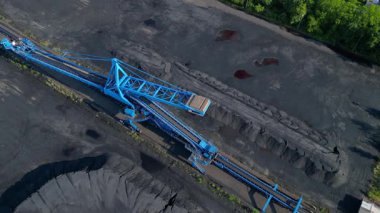 Kömür kazıcısını yerleşim alanı yakınlarındaki bir kömür terminalinde geri alan yayıcı. İHA kamerası aşağıya bakıyor 