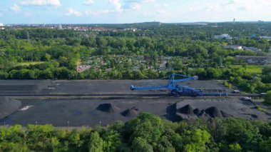 Kömür kazıcısını yerleşim alanı yakınlarındaki bir kömür terminalinde geri alan yayıcı. panorama genel görünüm dronu 