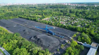Kömür kazıcısını yerleşim alanı yakınlarındaki bir kömür terminalinde geri alan yayıcı. Yukarıdan drone atışı 