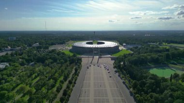 Günbatımında Olympiastadion Berlin 'in havadan görünüşü çan kulesini, park alanlarını ve şehrin ufuk çizgisini gösteriyor. İticileri ileri çalıştır 