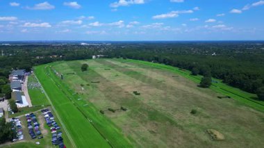 Güneşli bir yaz gününde yarışın tadını çıkaran izleyicilerle dolu bir at yarışı pistinin havadan görüntüsü. hız rampası hiper hareket zaman aşımı 