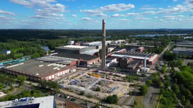Hennigsdorf çelik endüstrisinin hava manzarası. Endüstriyel binalar, bacalar, depolama alanı ve arka planda bir nehir. Hız rampası hiper hareket zaman aşımı sineği ileri it 