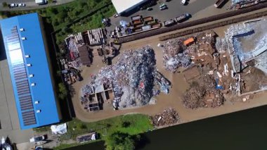 Atık ve yükleme kamyonlarını yöneten hurda metal geri dönüşüm merkezinin hava görüntüsü, Hennigsdorf, Almanya. dikey kuşların bakış açısı sağdaki drona döndür 
