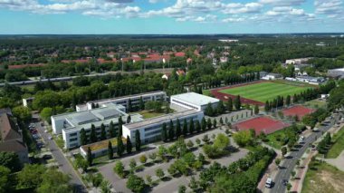Hennigsdorf Lisesi 'nin havadan görünüşü modern mimarisini, spor tesislerini, park alanını, kentsel manzarasını gözler önüne seriyor. statik üç ayaklı insansız hava aracı 