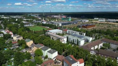 Hennigsdorf Lisesi 'nin havadan görünüşü modern mimarisini, spor tesislerini, park alanını, kentsel manzarasını gözler önüne seriyor. İticileri ileri çalıştır 