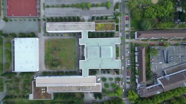 Hennigsdorf Lisesi 'nin havadan görünüşü modern mimarisini, spor tesislerini, park alanını, kentsel manzarasını gözler önüne seriyor. dikey kuşların bakış açısı İHA 'dan iniyor 