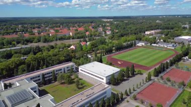 Hennigsdorf Lisesi 'ndeki spor tesisleri arasında futbol sahası, koşu pisti ve yerleşim alanlarındaki diğer binalar da var. Ters İHA uçuşu 