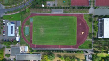 Hennigsdorf Lisesi 'ndeki spor tesisleri arasında futbol sahası, koşu pisti ve yerleşim alanlarındaki diğer binalar da var. İHA kamerası aşağıya bakıyor 