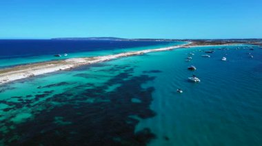 Kristal berrak turkuaz sularda yüzen sayısız yat ve tekneli kıyı şeridi. panorama yörünge dronu 