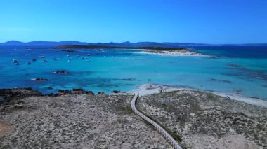 Beyaz kumlu plajları, turkuaz suları ve demirli tekneleri olan Espalmador adası. Arkadaki Ibiza ve Es Vedra adası. uçuş üstü insansız hava aracı 