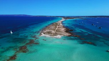 Punta des Borronar plajı Formentera adasında, yatları turkuaz sularla dolu. Yukarıdan drone atışı 