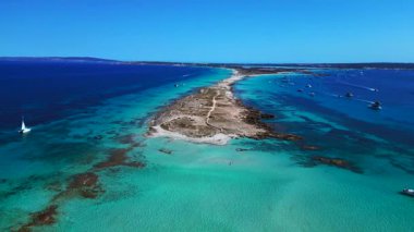 Punta des Borronar plajı Formentera adasında, yatları turkuaz sularla dolu. İHA alçalıyor 
