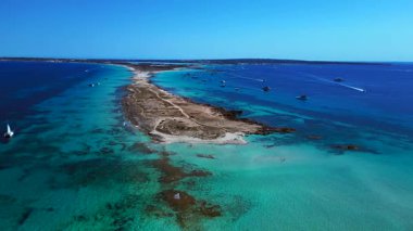 Punta des Borronar plajı Formentera adasında, yatları turkuaz sularla dolu. panorama yörünge dronu 