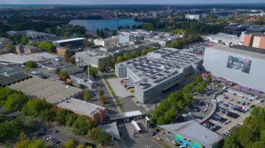 BMW motosiklet parkı, binalar, büyük bir fabrika, güneşli bir günde göl kenarında. Hız rampası hiper hareket zamanı hızlandırılmış panorama genel görünüm dronu 