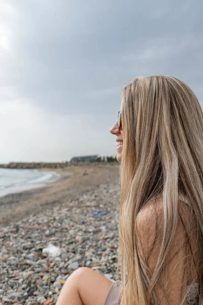 Woman Blonde Hair Sunglasses Smiling Looking Sea Cloudy Day — Stock Photo, Image