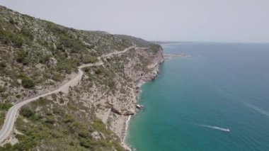 4K Aerial drone view of curves of coastal road with vehicles shot over seashore Garraf coast.