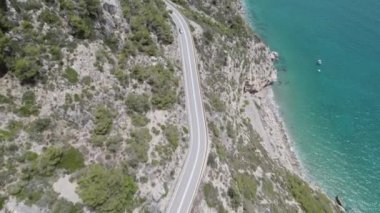 4K Aerial drone top down view of curves of coastal road with vehicles shot over seashore Garraf coast.
