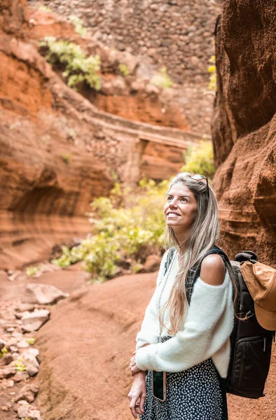 Kafasında güneş gözlüğü olan sarışın beyaz kadın portresi Gran Canaria, Kanarya Adaları 'ndaki Barranco de las Vacas kanyonunu keşfediyor.