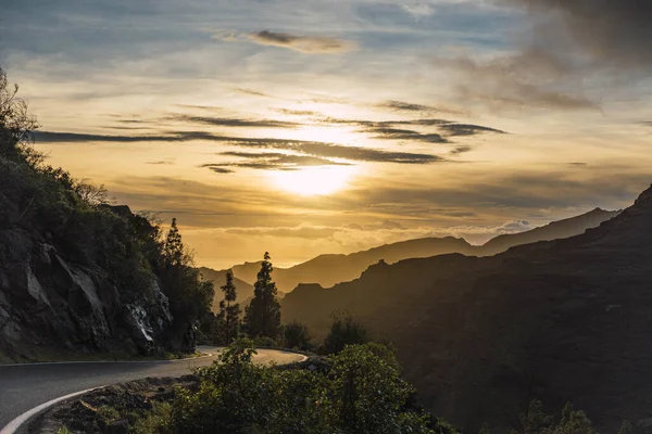 Sunset landscape of mountains and road in the middle of the nature with clouds. Canary islands