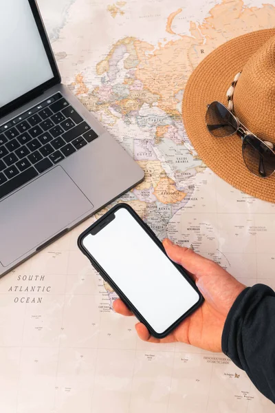 Unerkennbare Person Mit Smartphone Weißer Bildschirmkopierfläche Schreibtisch Weltkarte Sonnenbrille Und — Stockfoto