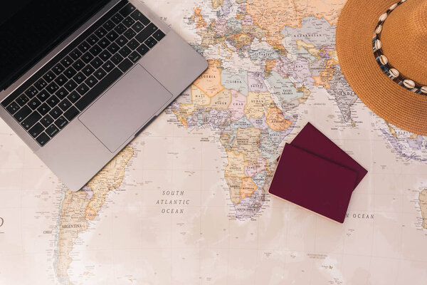 Travel concept. Desk world map with passports, laptop and hat, copy space