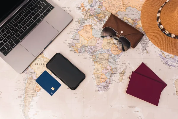 Reisekonzept Schreibtisch Weltkarte Mit Reisepass Laptop Hut Kreditkarte Und Smartphone — Stockfoto