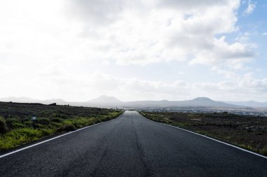 Gün batımında boş asfalt otoyolu ve arka planda tarlalar