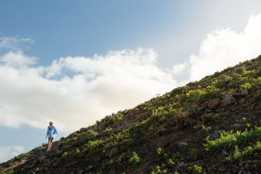 Şapka yürüyüşü yapan sarışın bir kadın, doğada egzersiz yapıyor. Başarı keşfi