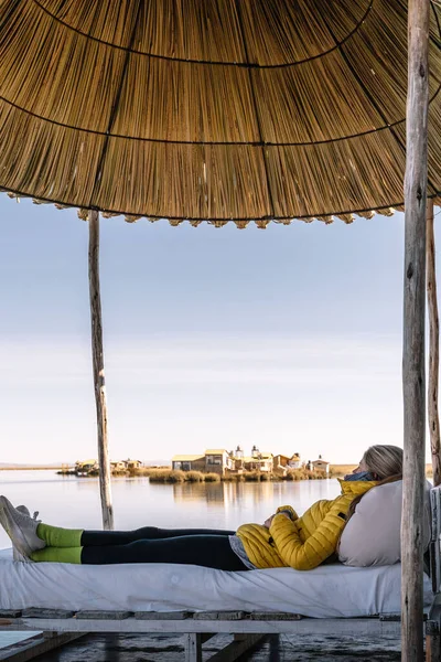 Sarışın kadın Güney Amerika, Peru 'daki Titicaca Gölü' nde Uros 'ta dinleniyor.