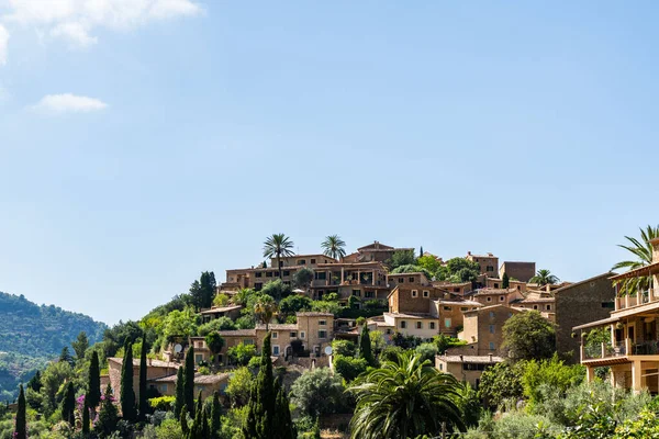İspanya, Mallorca 'daki Deia köyü. Yeşil ağaçlarla çevrili tepelerdeki teraslarda geleneksel evler. İspanyol turizm merkezleri.