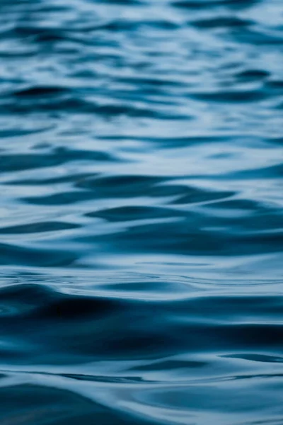 Vertical photo of the texture of the soft waves of a calm blue sea