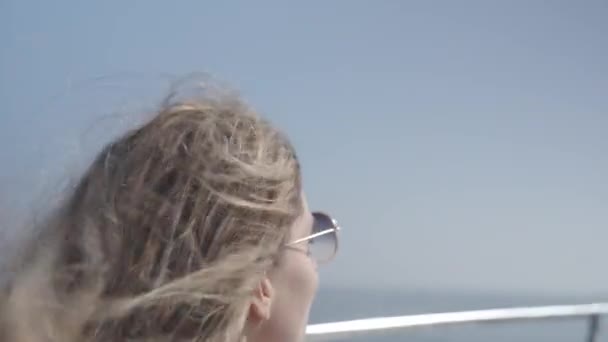4K一个金发女人在快速的小船上观察天空和海洋时 头发的实时运动视频 — 图库视频影像