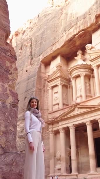 ペトラの古代都市 財務省でブロンドの観光客の女性の垂直ビデオ ヨルダンの歴史的 考古学的な都市 旅行先について — ストック動画