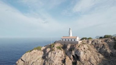 Güneşli bir günde bir deniz fenerinin hava aracı görüntüsü. Mayorka Adası, İspanya 'daki Artrutx deniz feneri
