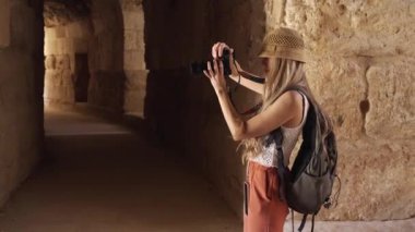 Sarışın turist şapkalı kadının Antik Jerash, Ürdün 'de fotoğraf çektiği 4K video.