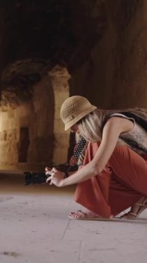 Sarışın turist kadının Antik Jerash, Ürdün 'de düşük fotoğraf çekerken çekilmiş dikey videosu.