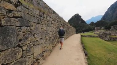 4k video, Peru 'daki Machu Pichu Kalesi' nde kayıp şehirde yürüyen ve selfie çeken sarışın kadın.