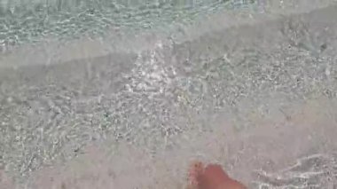 4k video Pov adam turkuaz denizde tropik bir plajda yürüyor. Seyahat tatili.