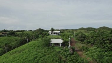 4K video geriye doğru uçuyor. Tropikal ağaçlarla orman manzaralı. Hava durumu yağmuru ve bulutlar. Evleri olan Panama ormanı